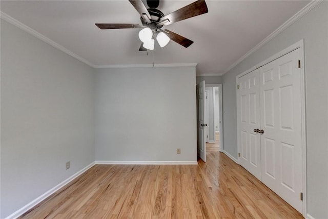 unfurnished bedroom featuring a closet, crown molding, light wood-style flooring, and baseboards