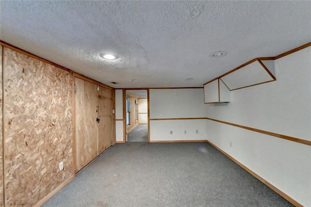 carpeted empty room featuring crown molding, a textured ceiling, and baseboards