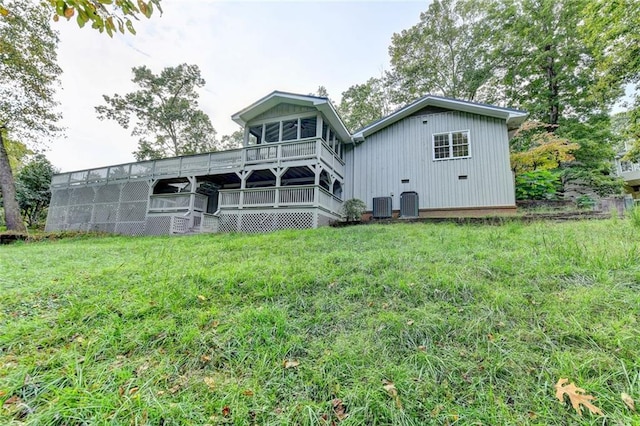 rear view of house with central AC, a lawn, and a deck