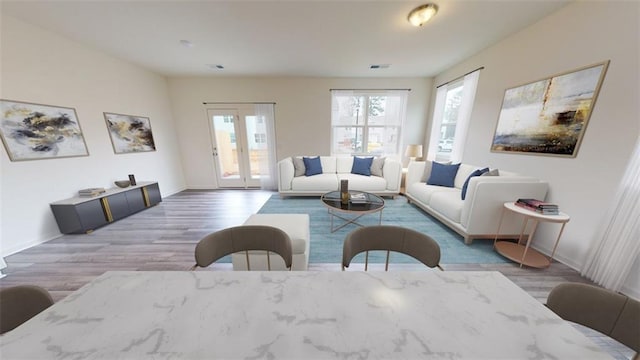 living area featuring wood finished floors, visible vents, and baseboards