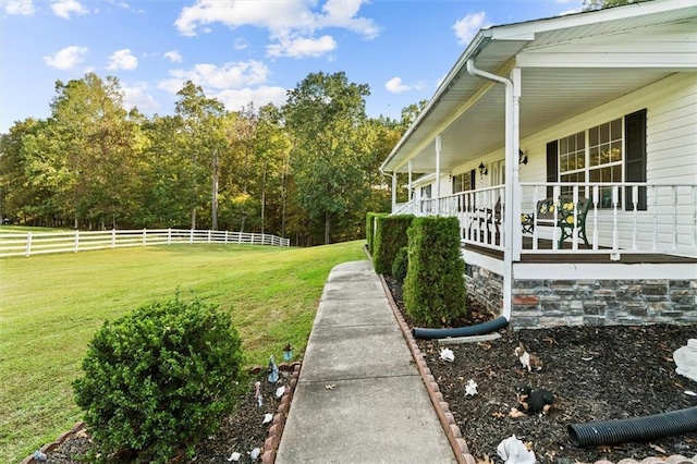 view of yard featuring a porch and fence