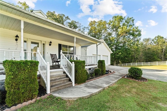 property entrance with a garage, driveway, a porch, and fence