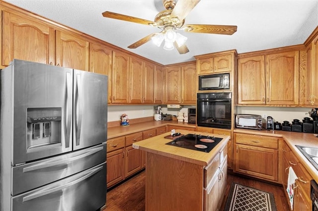 kitchen with a center island, a toaster, dark wood-type flooring, ceiling fan, and black appliances