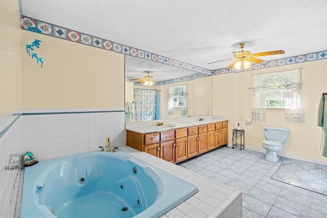 bathroom featuring double vanity, toilet, a whirlpool tub, tile patterned flooring, and a textured ceiling