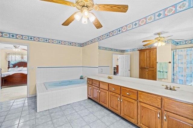 ensuite bathroom featuring double vanity, connected bathroom, a sink, tile patterned flooring, and a bath