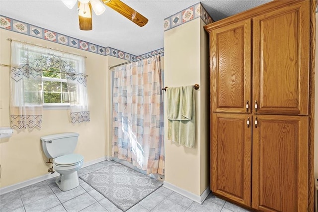 bathroom featuring a shower with shower curtain, toilet, a ceiling fan, tile patterned flooring, and baseboards