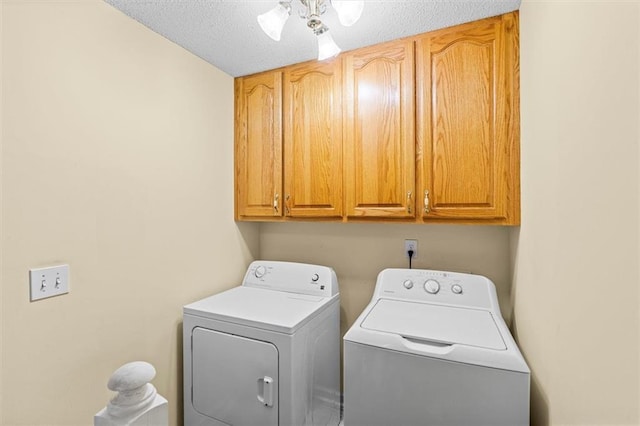 laundry area featuring a textured ceiling, separate washer and dryer, cabinet space, and a ceiling fan