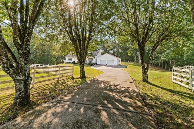 view of front of home with a front yard, fence, and a detached garage