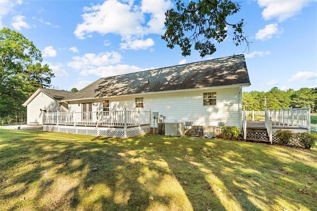 back of property with a lawn and a wooden deck