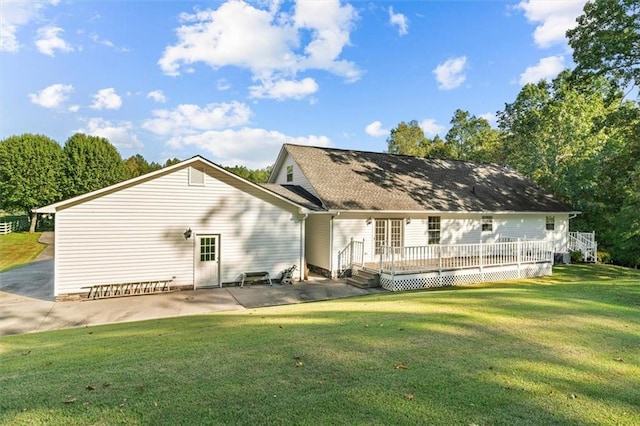 back of property with a yard, a deck, and a patio