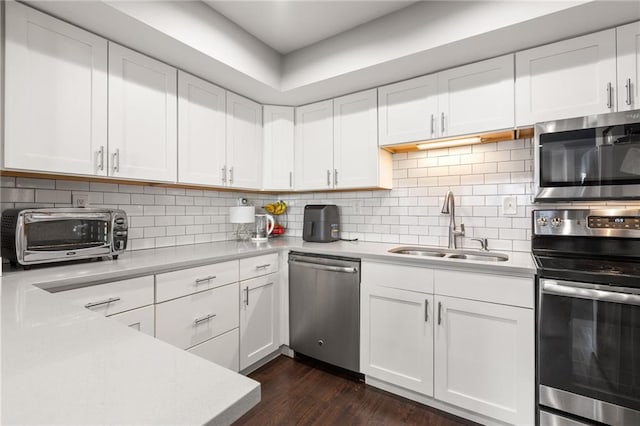 kitchen with backsplash, stainless steel appliances, sink, and white cabinets