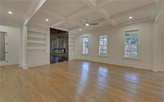 unfurnished living room featuring built in shelves, beam ceiling, wood-type flooring, and ceiling fan