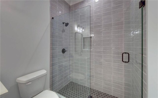 bathroom featuring an enclosed shower and toilet