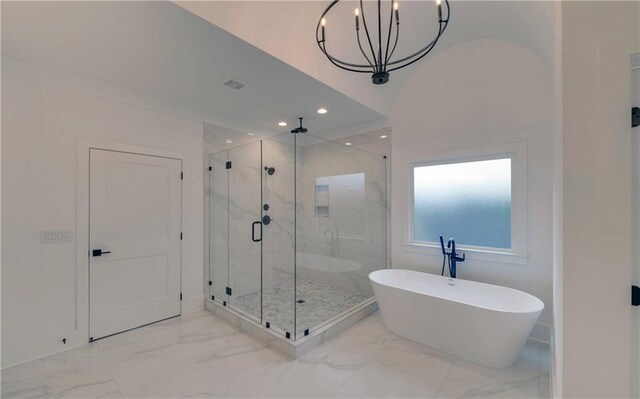 bathroom with a notable chandelier and shower with separate bathtub