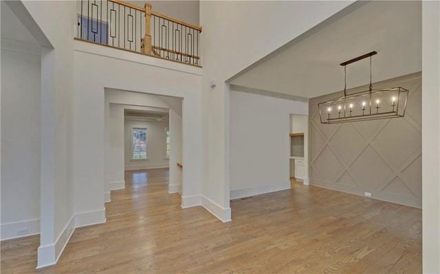 foyer entrance with an inviting chandelier and light wood-type flooring