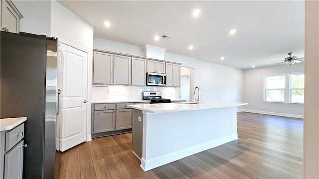 621 Pineberry Ct, Grayson, GA 30017 - kitchen featuring appliances with stainless steel finishes, gray cabinetry, wood finished floors, a sink, and light countertops