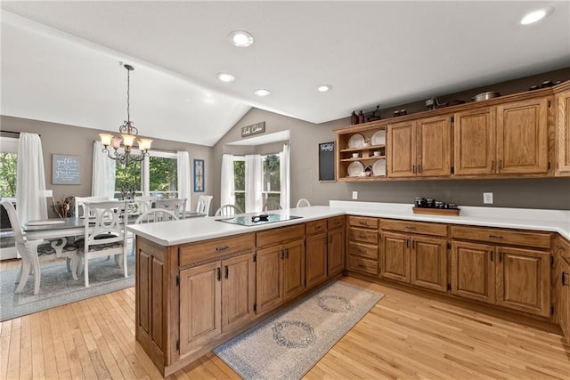 kitchen featuring decorative light fixtures, vaulted ceiling, light hardwood / wood-style flooring, kitchen peninsula, and black electric stovetop