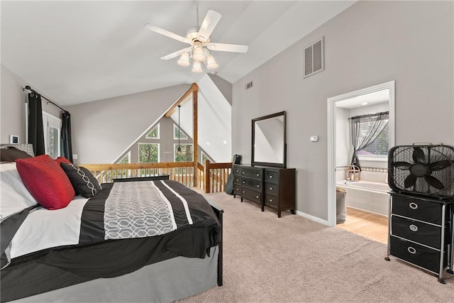 carpeted bedroom with ceiling fan, lofted ceiling, and ensuite bath