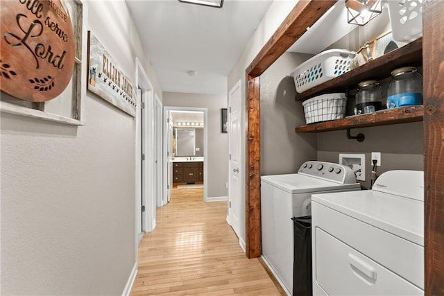 laundry room featuring washing machine and dryer and light hardwood / wood-style floors