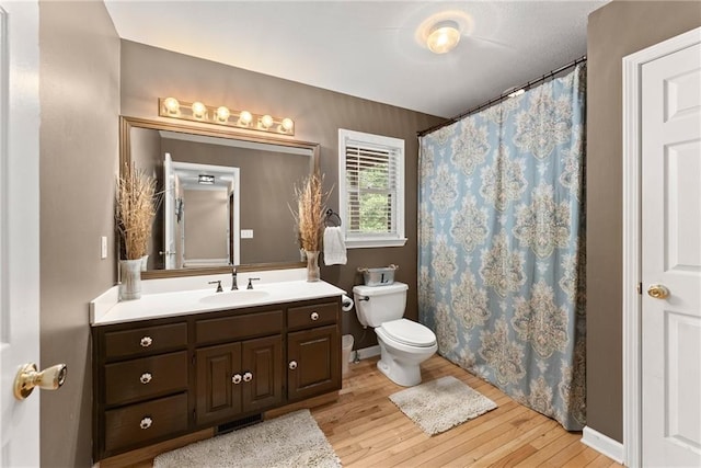 bathroom featuring hardwood / wood-style flooring, vanity, toilet, and a shower with shower curtain