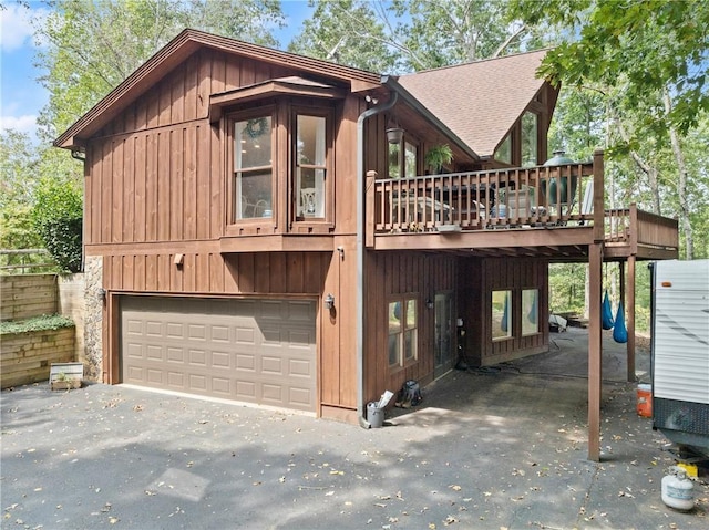 view of side of home with a wooden deck and a garage