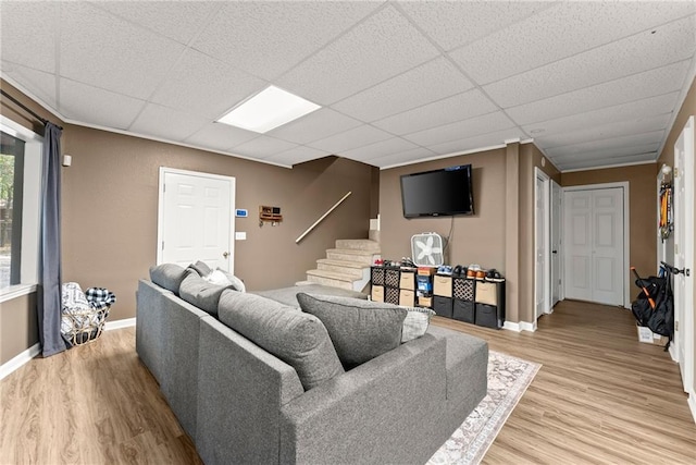 living room featuring a paneled ceiling and light wood-type flooring