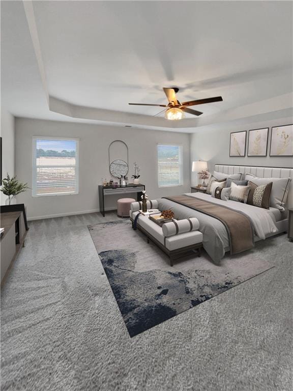 bedroom featuring multiple windows, carpet floors, a tray ceiling, and ceiling fan