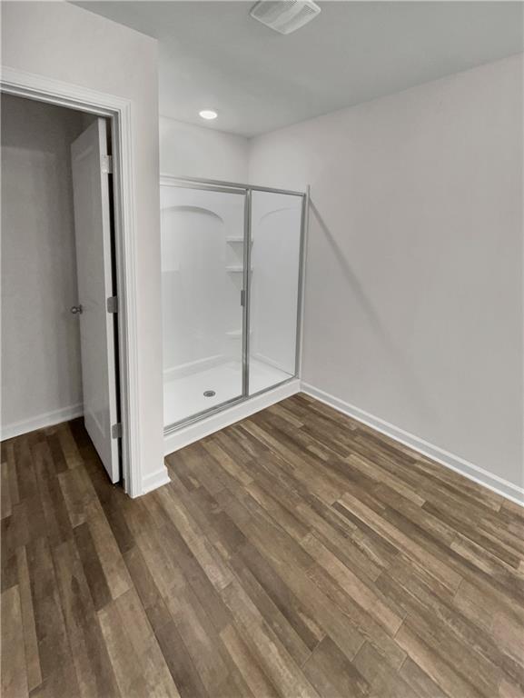 bathroom with walk in shower and hardwood / wood-style flooring