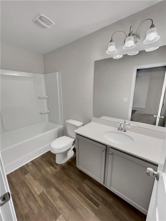 full bathroom featuring shower / bathing tub combination, vanity, toilet, and wood-type flooring