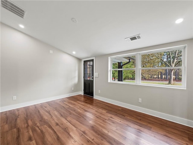 empty room featuring wood finished floors and visible vents