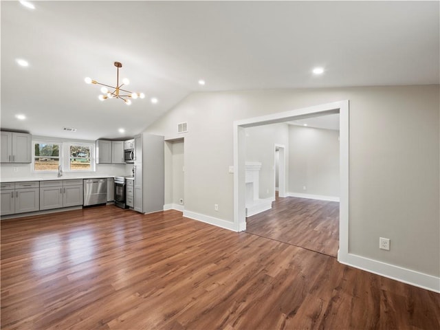 unfurnished living room featuring dark wood-style floors, lofted ceiling, visible vents, a chandelier, and baseboards