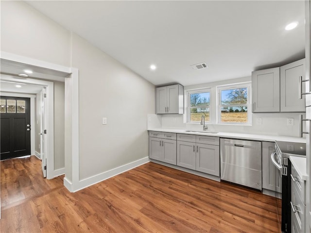 kitchen with visible vents, stainless steel appliances, light countertops, gray cabinetry, and a sink