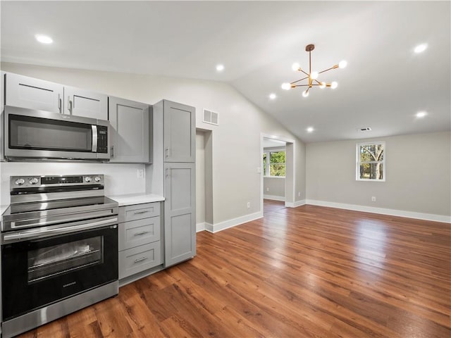 kitchen featuring visible vents, lofted ceiling, stainless steel appliances, light countertops, and gray cabinetry