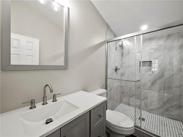 bathroom featuring a stall shower, vanity, and toilet