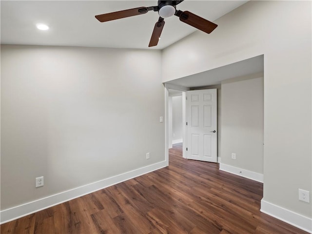 spare room with dark wood-style floors, a ceiling fan, and baseboards