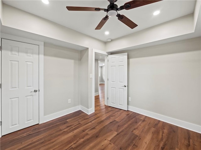 unfurnished bedroom featuring dark wood-type flooring, recessed lighting, a ceiling fan, and baseboards