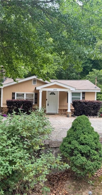 view of front facade featuring stone siding and driveway