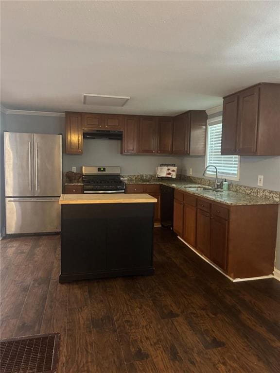 kitchen with stainless steel appliances, a sink, dark wood-style flooring, a kitchen island, and under cabinet range hood
