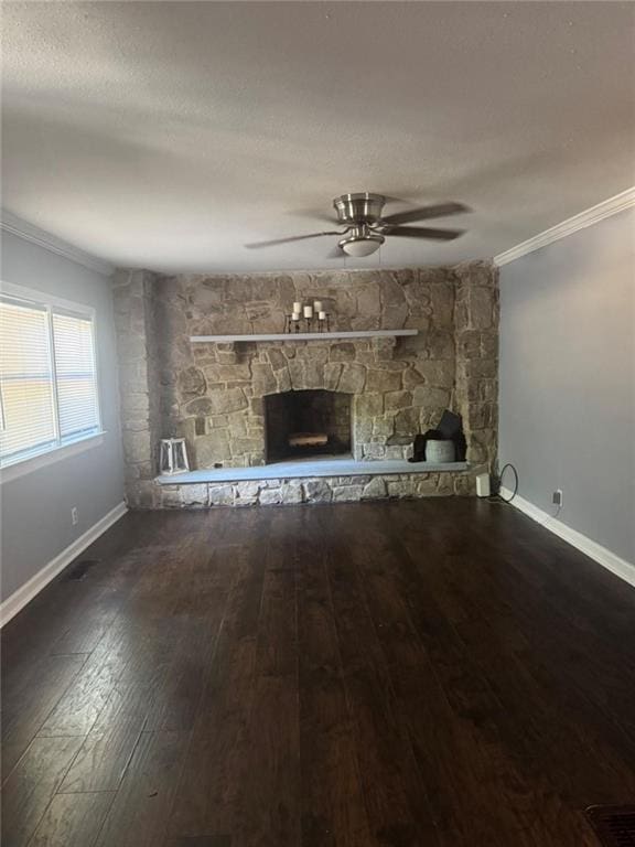 unfurnished living room featuring crown molding, a stone fireplace, hardwood / wood-style flooring, ceiling fan, and baseboards