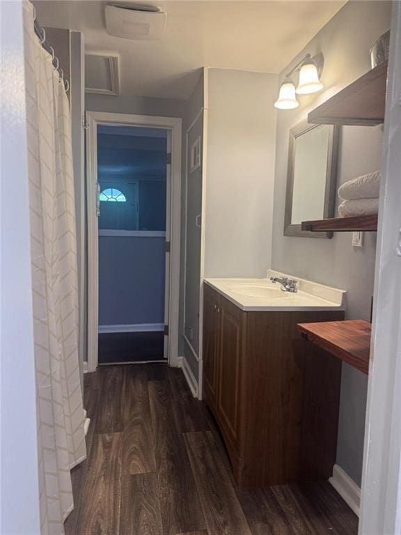 bathroom featuring wood finished floors, vanity, and baseboards