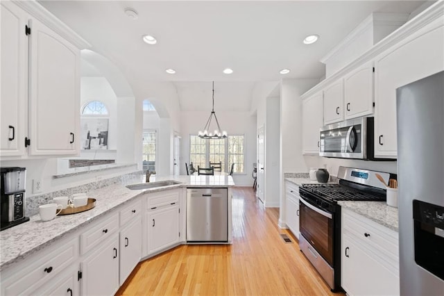 kitchen featuring white cabinetry, sink, pendant lighting, and appliances with stainless steel finishes