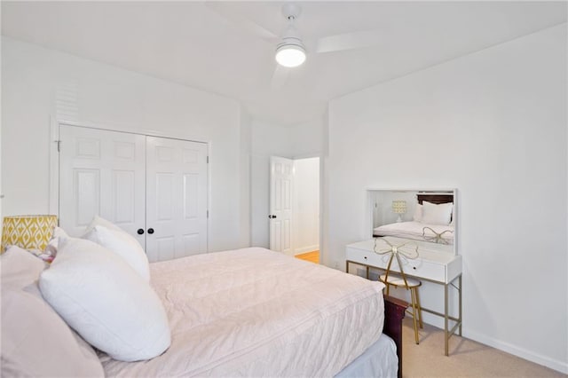 bedroom featuring light carpet, ceiling fan, and a closet