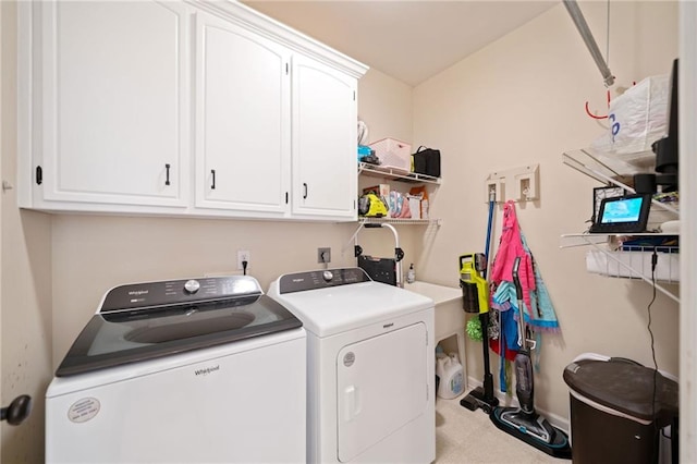 clothes washing area featuring cabinets and washing machine and dryer