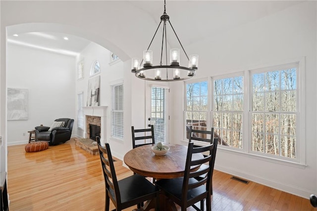 dining space featuring wood-type flooring and a stone fireplace