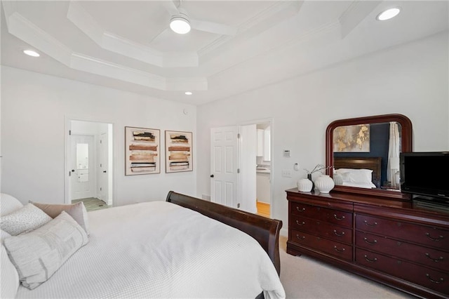 bedroom featuring ceiling fan, ensuite bath, crown molding, and a raised ceiling