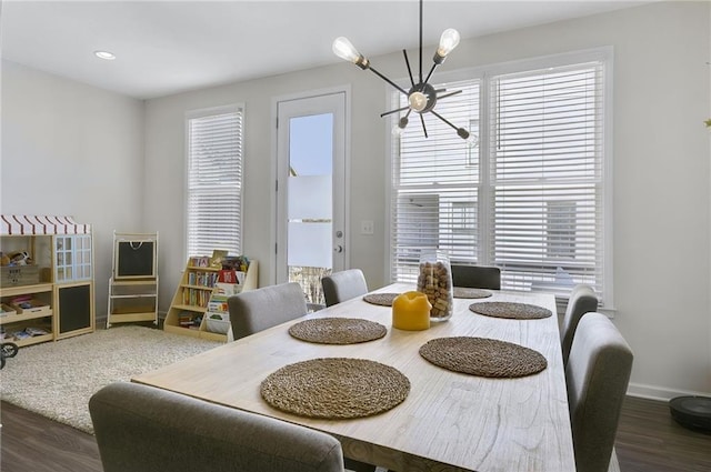 dining area with recessed lighting, baseboards, an inviting chandelier, and wood finished floors