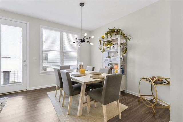 dining space featuring a notable chandelier, baseboards, and dark wood-style flooring