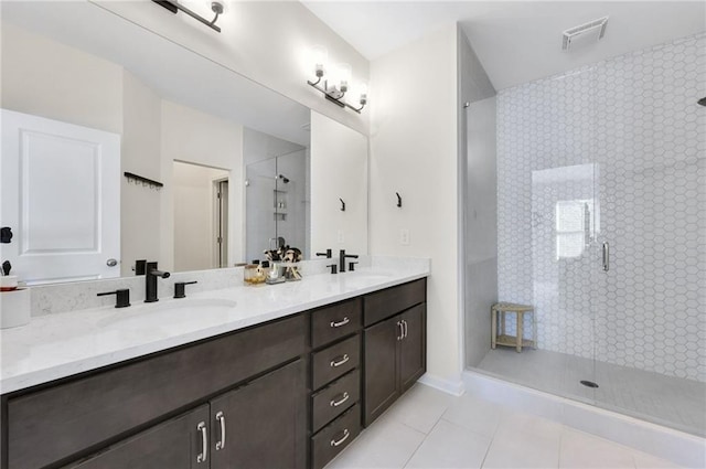 bathroom with a shower stall, double vanity, visible vents, and a sink