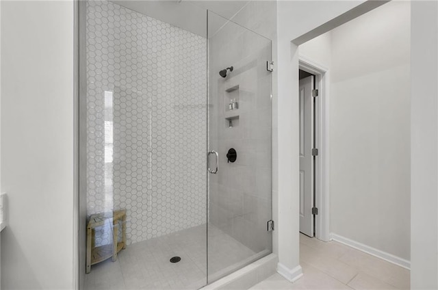 bathroom with baseboards, a stall shower, and tile patterned flooring