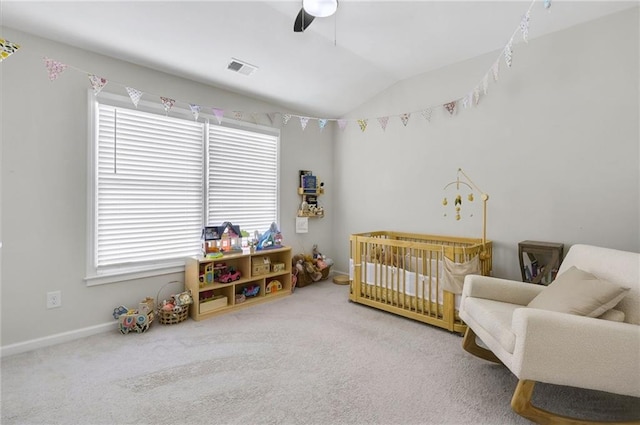 bedroom with visible vents, a crib, ceiling fan, carpet floors, and vaulted ceiling